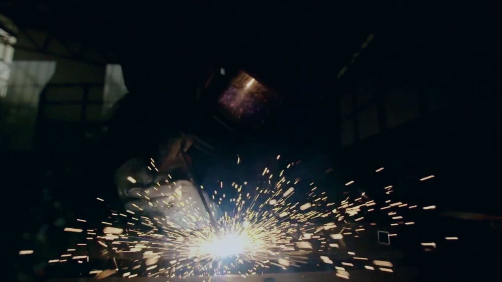 An angle grinder throwing sparks across a steel workpiece