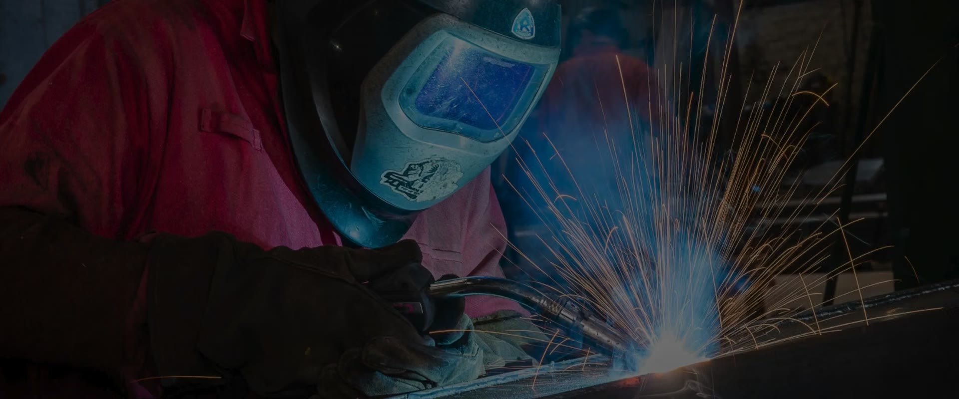A welder at work in an Eldapoint workshop, sparks flying from the torch